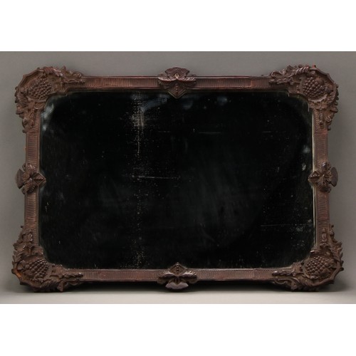 2027 - A 19th century Continental pearwood mirror, the corners elaborately carved with fruiting vine, 68cm ... 