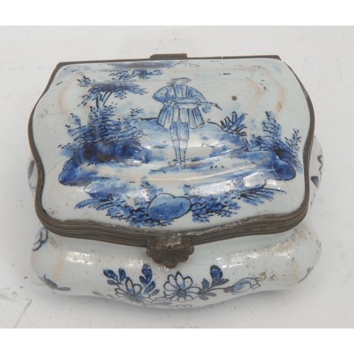 1521 - A 19th century Delftware enamel snuff box, the hinged cover mounted with a young man plucking a fidd... 