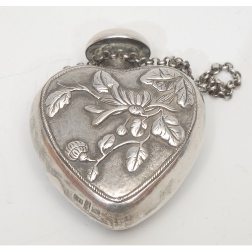 213 - A Chinese export ware silver heart-shaped scent bottle, cast with panels of a dragon and blossoming ... 