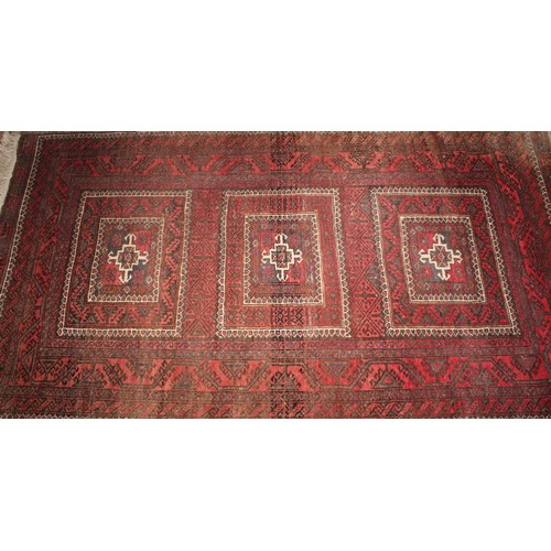 2054 - A Belouch hand knotted rug, with traditional motifs  in tones of red, black, brown, cream, approx 17... 