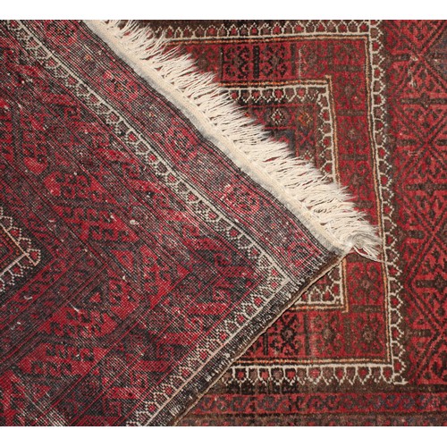 2054 - A Belouch hand knotted rug, with traditional motifs  in tones of red, black, brown, cream, approx 17... 