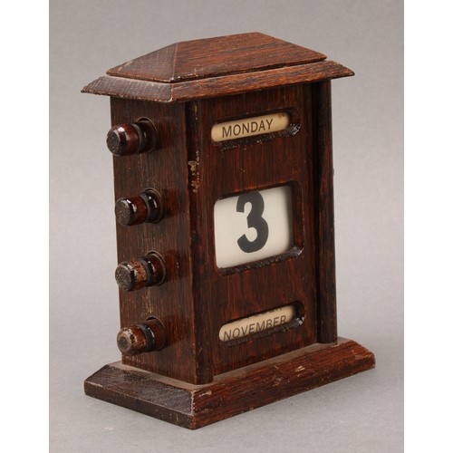 1886 - An early 20th century oak perpetual desk calendar, sarcophagus cresting above glazed apertures for d... 