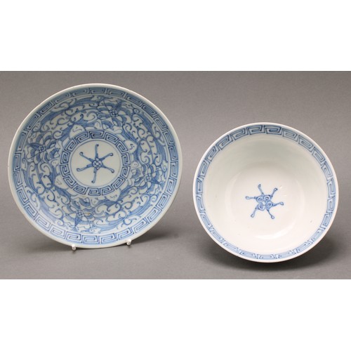 1402 - A Chinese klapmuts bowl and stand, painted in tones of underglaze blue with flowers and leafy scroll... 