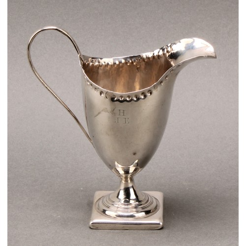 118 - A George III helmet shaped silver cream jug, punch beaded border, scroll handle, square base, 12.5cm... 