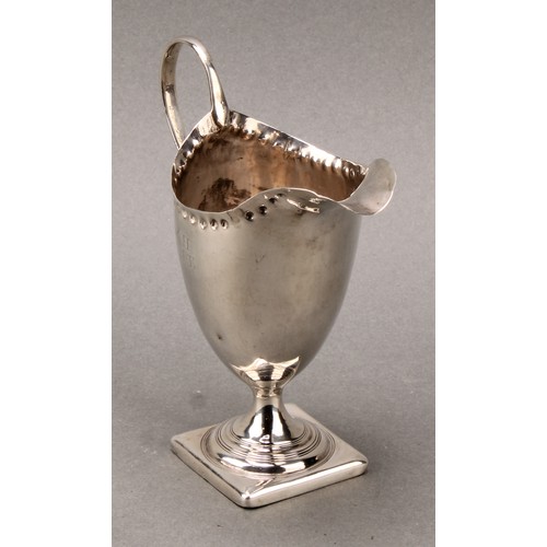 118 - A George III helmet shaped silver cream jug, punch beaded border, scroll handle, square base, 12.5cm... 