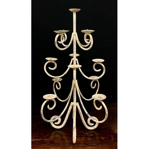 2005 - A wrought iron candle tree, with three levels of four scrolling arms beneath smaller top, dished wax... 