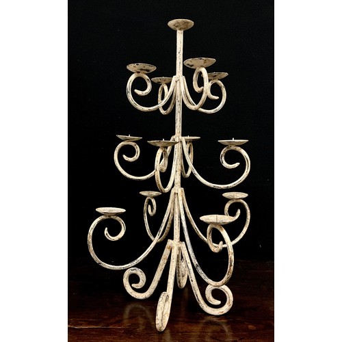 2005 - A wrought iron candle tree, with three levels of four scrolling arms beneath smaller top, dished wax... 