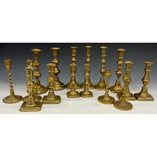 1663 - A near set of four brass candlesticks, 22.3cm high other pairs, smallest 15cm high