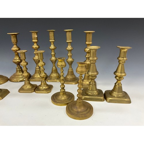 1663 - A near set of four brass candlesticks, 22.3cm high other pairs, smallest 15cm high