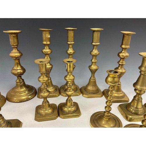 1663 - A near set of four brass candlesticks, 22.3cm high other pairs, smallest 15cm high