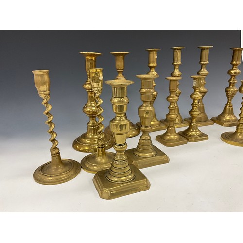 1663 - A near set of four brass candlesticks, 22.3cm high other pairs, smallest 15cm high