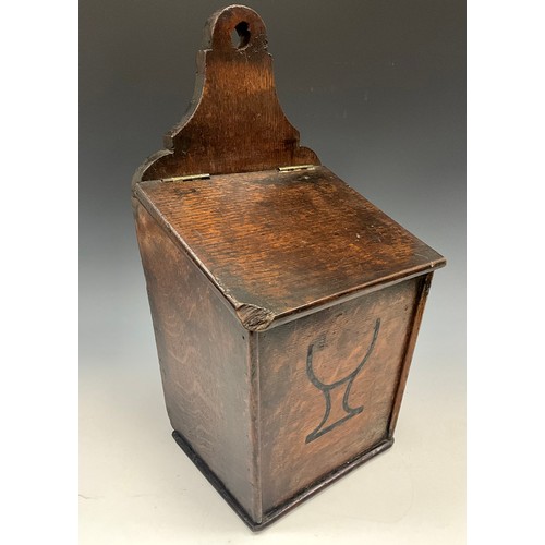 1929 - A George III oak candle box, shaped cresting, hinged sloping cover, the front decorated with a chali... 