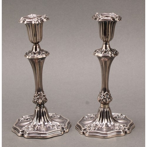 157 - A pair of William IV/early Victorian silver taper sticks, fluted borders chased with leaves, loaded,... 