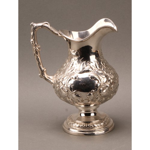 451 - An American silver baluster beer jug or pitcher, profusely chased with flowers and foliage, branch h... 