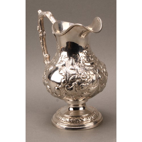 451 - An American silver baluster beer jug or pitcher, profusely chased with flowers and foliage, branch h... 