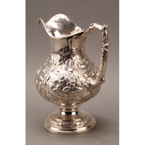 451 - An American silver baluster beer jug or pitcher, profusely chased with flowers and foliage, branch h... 