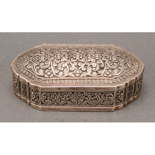 484 - An Indian silver shaped rectangular table snuff or tobacco box, profusely chased with lotus and scro... 