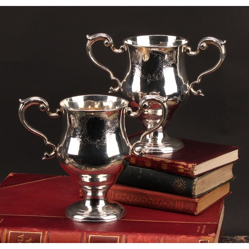 384 - A pair of George III Irish silver pedestal bell shaped loving cups, acanthus-capped scroll handles, ... 