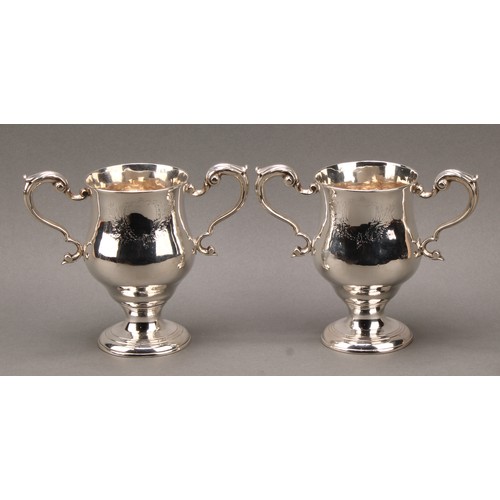 384 - A pair of George III Irish silver pedestal bell shaped loving cups, acanthus-capped scroll handles, ... 