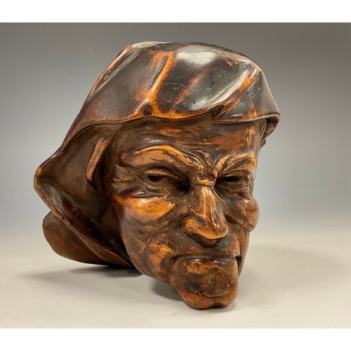 1821 - A Continental walnut boss or corbel, carved as a grimacing man, 11cm long, 18th/19th century