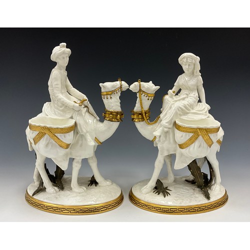 1300 - A pair of unusual Moore Bros figural vases, as turbaned figures riding Camels, with saddlebag bowl s... 