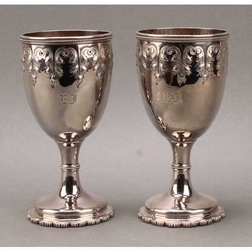 234 - Tiffany & Co - a pair of 19th century American silver pedestal goblets, chased in the Gothic taste w... 