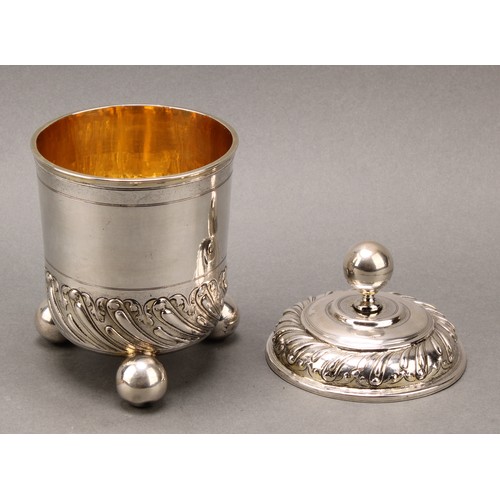 100 - A 17th century German silver beaker and cover, chased with bands of wrythen fluting and scrolling ac... 