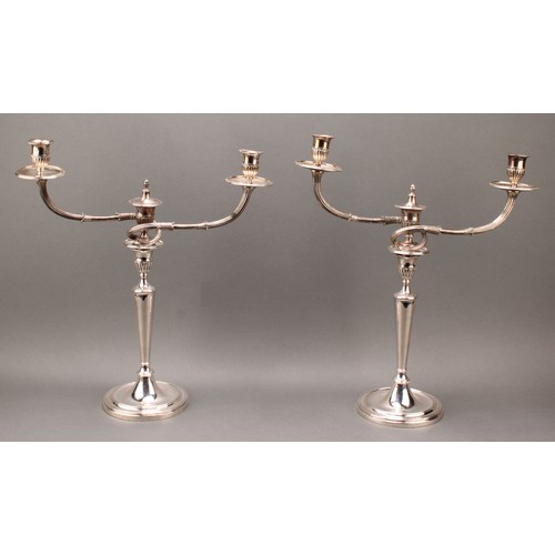 383 - A pair of George III cast silver two-light table candelabra, batwing-fluted campana sconces, acanthu... 