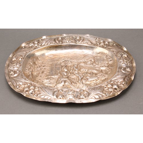 101 - A 17th century German silver oval tray, chased with a courting couple in an Arcadian landscape, with... 