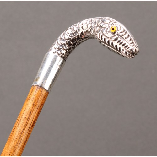 1764 - An Edwardian silver mounted walking stick, the handle as a snake's head, palmwood cane, glass eyes, ... 