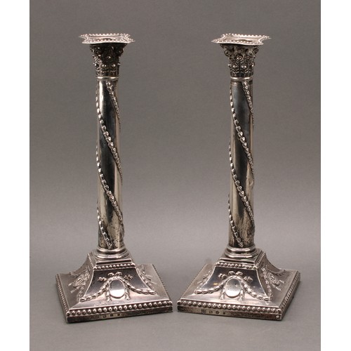 385 - A pair of George III silver Corinthian column candlesticks, chased in the Neo-Classical taste with r... 