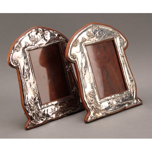 147 - A pair of Art Nouveau period silver easel photograph frames, embossed in the Aesthetic Movement tast... 