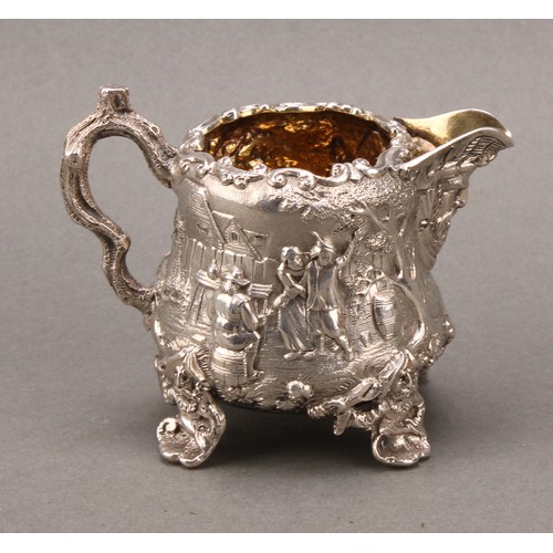 275 - A Victorian silver pear shaped Teniers cream jug, cast with tavern scenes, gilt interior, 8cm high, ... 