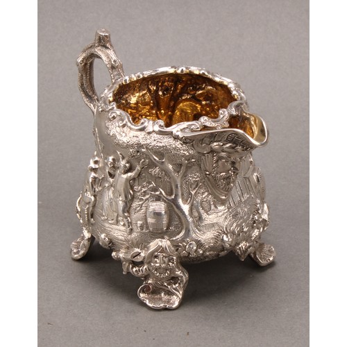 275 - A Victorian silver pear shaped Teniers cream jug, cast with tavern scenes, gilt interior, 8cm high, ... 