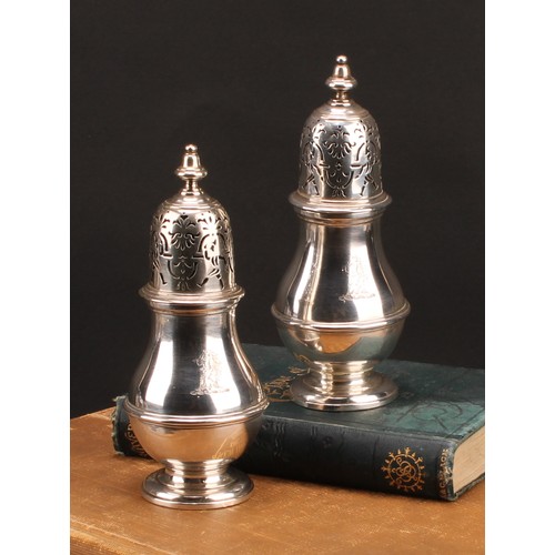 1497 - A pair of unusual George I silver pear shaped casters, knop finials, the bell shaped covers with rar... 