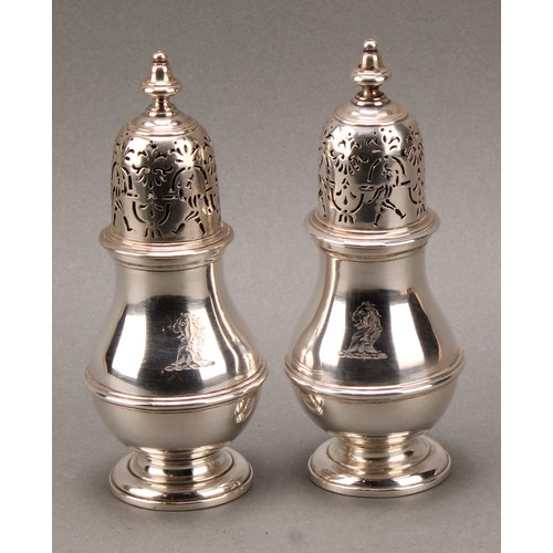 1497 - A pair of unusual George I silver pear shaped casters, knop finials, the bell shaped covers with rar... 