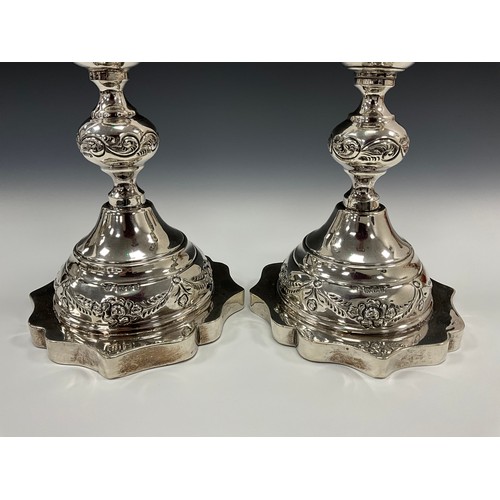 186 - Judaica - a pair of large George V Jewish Sabbath candlesticks, embossed with floral swags and scrol... 