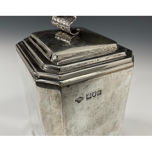 338 - An Art Deco silver tea caddy, stepped hinged cover with curled leaf handle, plain canted square body... 