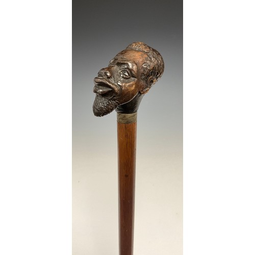 1754 - A Victorian figural walking stick, the pommel carved as a man of African descent, glass eyes, silver... 