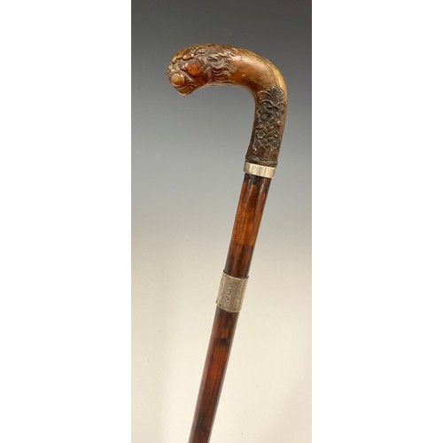 1750 - A George V walking stick, the horn handle carved with a lion head and terminating with a floral arra... 