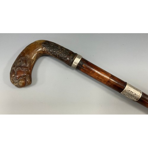 1750 - A George V walking stick, the horn handle carved with a lion head and terminating with a floral arra... 