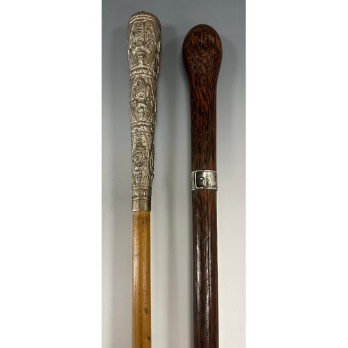 1763 - An early 20th century walking stick, the white metal mounted pommel cast with graduated panels of Bu... 