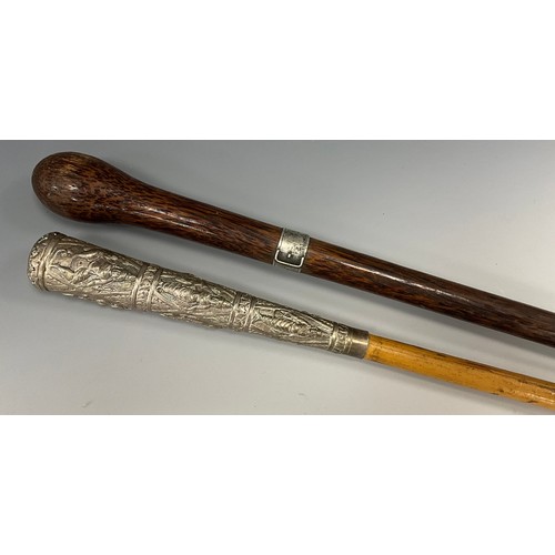 1763 - An early 20th century walking stick, the white metal mounted pommel cast with graduated panels of Bu... 