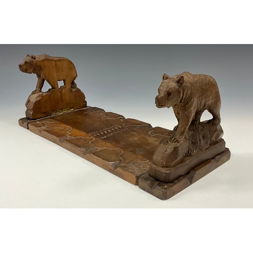 1544 - A 19th century Black Forest book carrier, the hinged ends carved as bears on rocky outcrops, applied... 