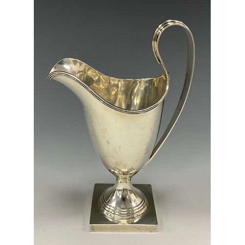 471 - An Edwardian silver helmet shaped cream jug, reeded scroll handle, stepped circular foot, square bas... 