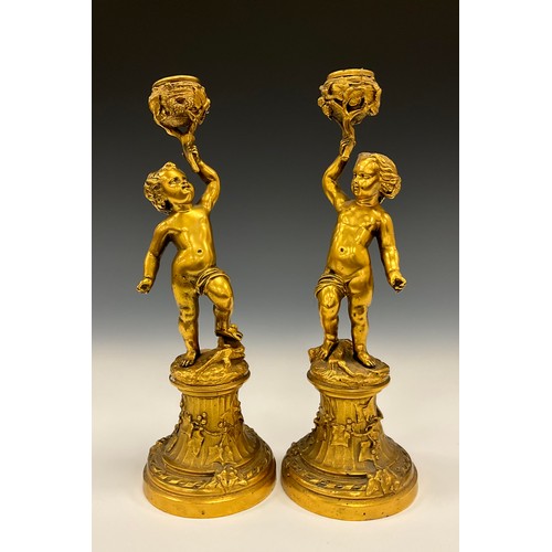 1846 - A pair of 19th century gilt metal figural candlesticks, each cast as a scantily clad putto, 26cm hig... 