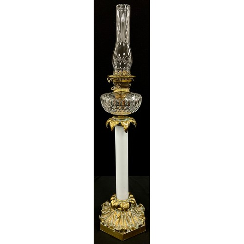 2000 - A 19th century gilt metal oil lamp, opaque milk glass column, fitted on acanthus scroll on hexagonal... 