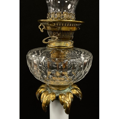 2000 - A 19th century gilt metal oil lamp, opaque milk glass column, fitted on acanthus scroll on hexagonal... 