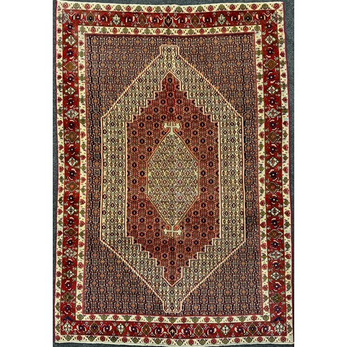 2061 - A North West Persian Senneh carpet, knotted with concentric hexagonal form medallions within a patte... 