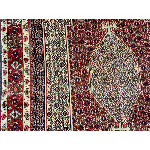 2061 - A North West Persian Senneh carpet, knotted with concentric hexagonal form medallions within a patte... 